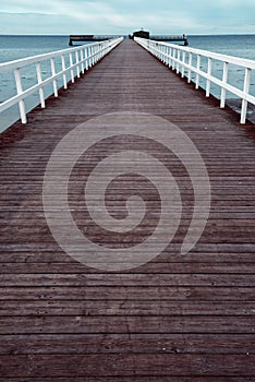 Empty wooden pier walkway on sea shore