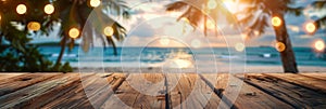 Empty wooden planks table against a blurred background with a sea coast with palm trees and glowing light bulbs in the