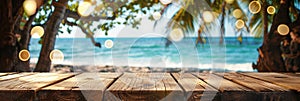 Empty wooden planks table against a blurred background with a sea coast with palm trees and glowing light bulbs in the