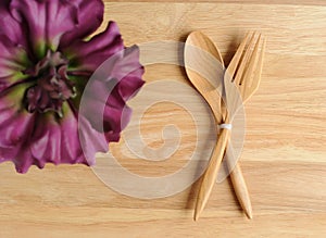 empty wooden plate with fork and flower decorate