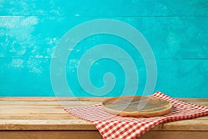 Empty wooden plate or tray on kitchen table with tablecloth over