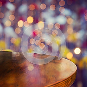 Empty wooden round table over bokeh lights beautiful background