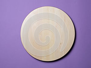 Empty wooden round tray on lilac background