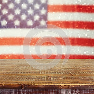 Empty wooden rustic table over USA flag bokeh background. USA national holidays background. 4th of July celebration.