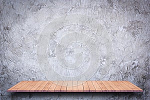 Empty wooden shelf with bare concrete background.