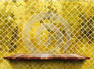 Empty wooden shelfs on glossy mosaic gold tile wall, Mock up template for display of product