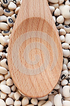 Empty wooden spoon on Black-eyed Beans background.