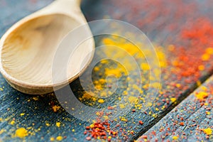 Empty wooden spoon on table covered in spices