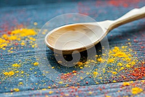 Empty wooden spoon on table covered in spices