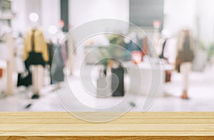 Empty brown wooden table and De focused,blurry background of clothing store with bokeh image luxury and fashionable brand
