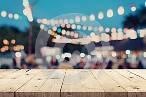 Empty wooden table and blurred background at night market festival people walking on road with copy space, display montage for