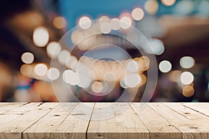 Empty wooden table and blurred background at night market festival people walking on road with copy space, display montage for