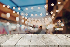 Empty wooden table and blurred background at night market festival people walking on road with copy space, display montage for