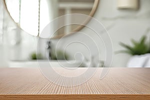 Empty wooden table and blurred view of bathroom interior