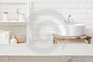 Empty wooden table and blurred view of bathroom sink interior