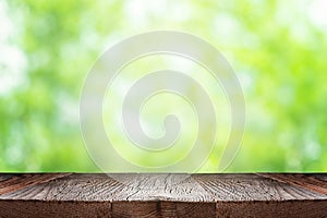 Empty wooden table or board over green blurred nature background