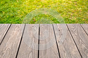 Empty wooden table on bright green abstract blurred background, for product display montage