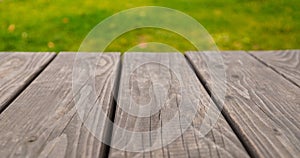 Empty wooden table on bright green abstract blurred background, for product display montage