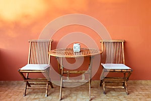 empty wooden table and chairs on the terrace on a summer day