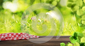 Empty wooden table with checkered napkin outdoors. Summer picnic