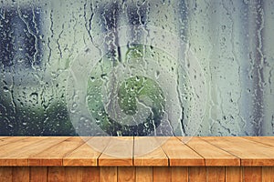 Empty wooden table and drop water in the window
