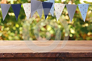 Empty wooden table with flags party background outdoors. for pro