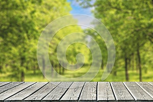 Empty wooden table or floor for product display against blurred garden alley