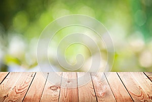 Empty wooden table with foliage bokeh