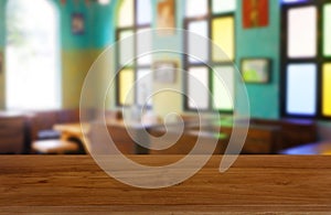 Empty wooden table in front of abstract blurred background of restaurant, cafe and coffee shop interior.