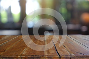 Empty wooden table in front of abstract blurred Cafe, restaurant at night. For montage product display or design key visual layout