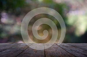 Empty wooden table in front of abstract blurred green of garden and nature light background. For montage product display or design