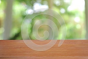 Empty wooden table in front of abstract blurred green of garden and nature light background. For montage product display or design