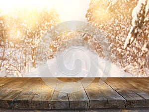 Empty wooden table in front of dreamy and magical winter landscape background. For product display montage.