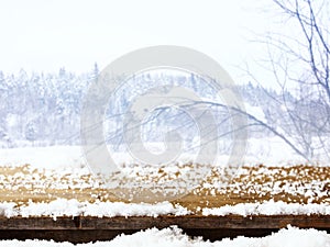 Empty wooden table in front of dreamy and magical winter landscape background. For product display montage.