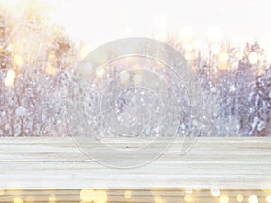 Empty wooden table in front of dreamy and magical winter landscape background. For product display montage.