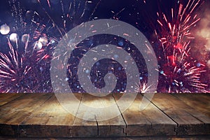 Empty wooden table in front of fireworks background