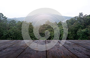 Empty wooden table in front of green nature and mountain background. For montage product display or design key visual layout -