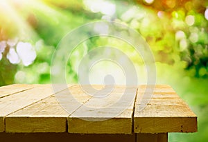 Empty wooden table with garden bokeh photo