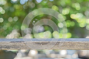 Empty wooden table with garden bokeh background with a country outdoor theme