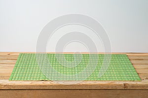 Empty  wooden table with green bamboo placemat. Chinese kitchen or restautant concept background photo