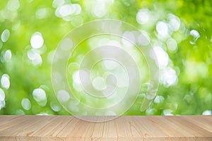 Empty wooden table on green nature background with beauty bokeh under sunlight