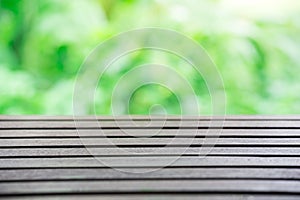 Empty wooden table with natural lighting and green background,Template for setting the products