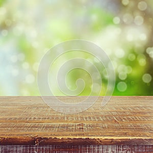 Empty wooden table over bokeh summer garden background