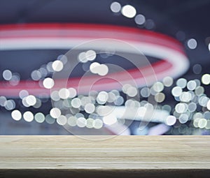 Empty wooden table over defocused light and shadow of shopping m