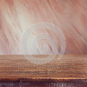 Empty wooden table over painted marsala color wall