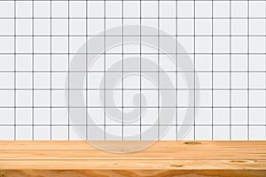 Empty wooden table over square ceramic tile background.