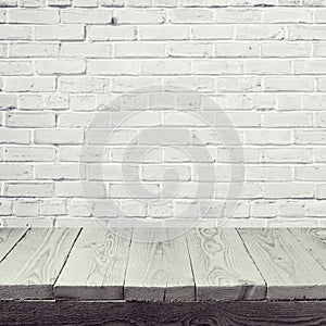 Empty wooden table over white brick wall background