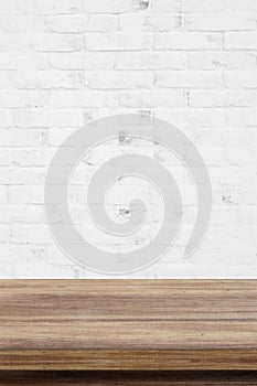 Empty wooden table over white brick wall background, for produc