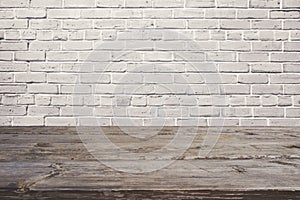 Empty wooden table over white brick wall. Background for product montage