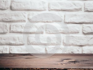 Empty wooden table over white brick wall. Background for product montage display